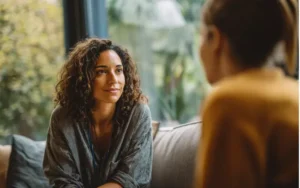 Compassionate counselor listening attentively to a patient during outpatient recovery session in New Hampshire.