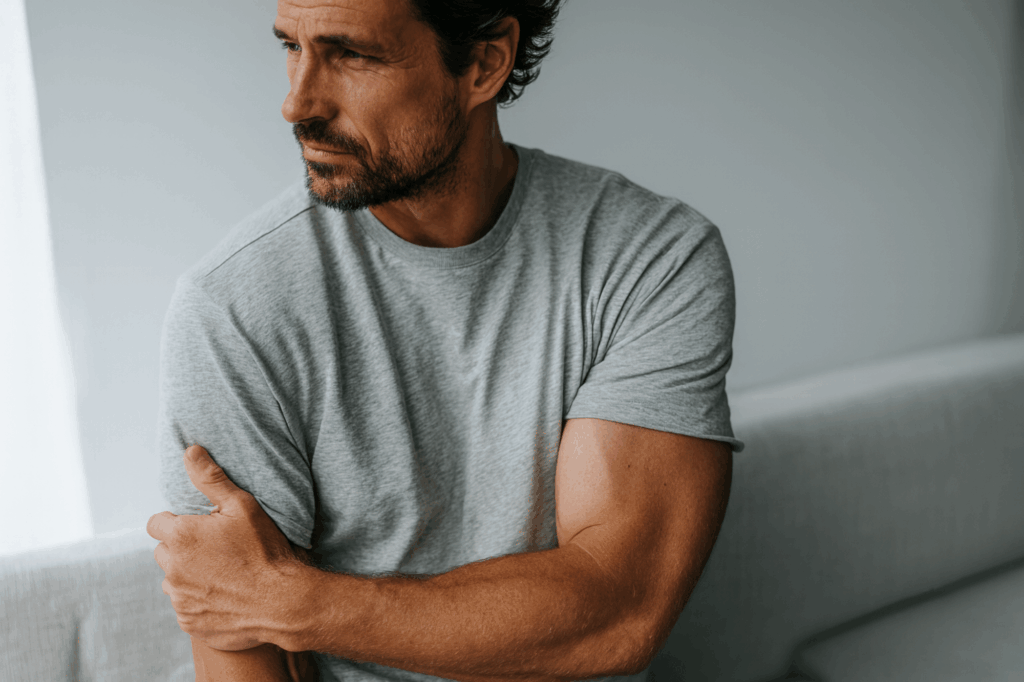 Person holding their arm due to muscle soreness