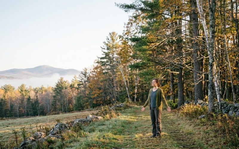 Person finding peace and healing in New Hampshire nature during trauma-focused addiction recovery