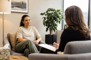 Person sitting in an individual therapy session at a New Hampshire outpatient treatment center, engaged in a calm and focused conversation with their therapist